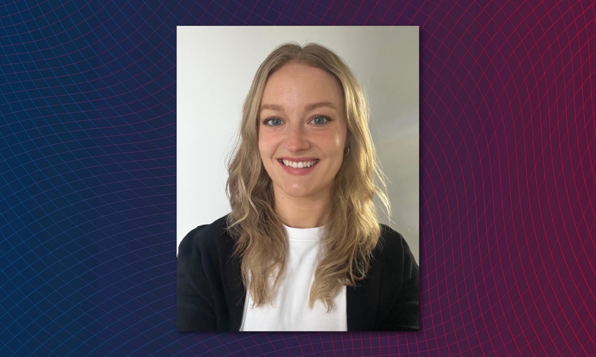 Kesh is a young woman with a warm smile, blue eyes and long, wavy blond hair. She is wearing a white top and a black cardigan.