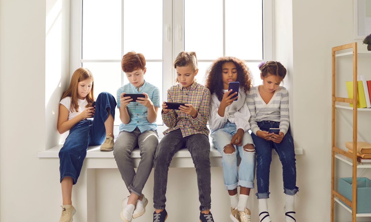 Children of different nationalities play online games or read social networks on mobile phones.