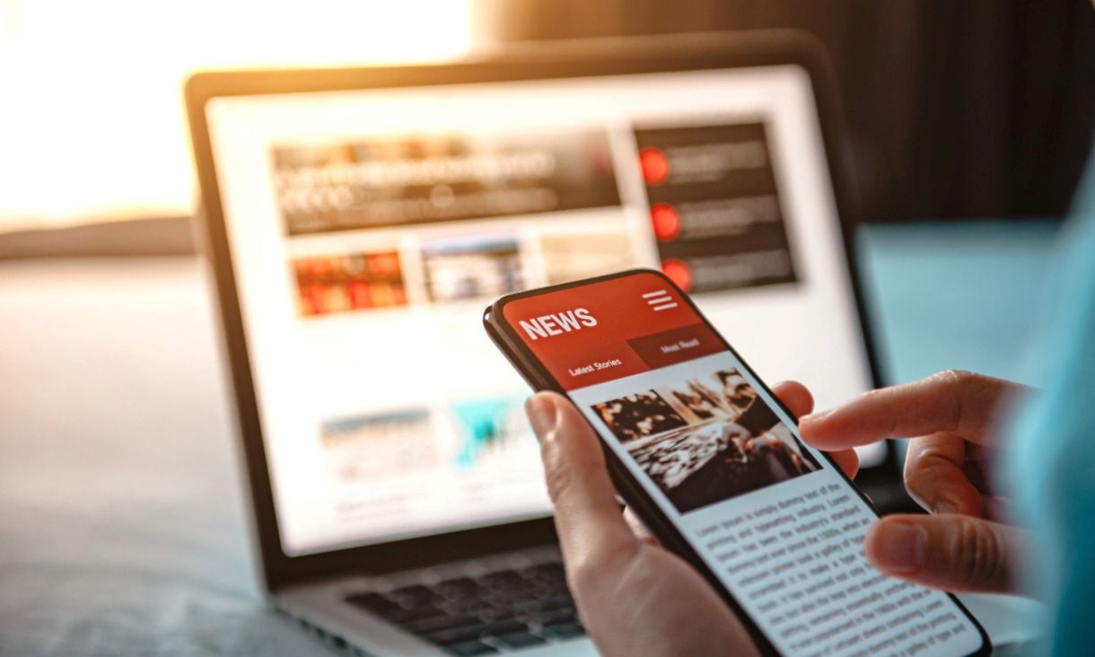 laptop and mobile phone on news site
