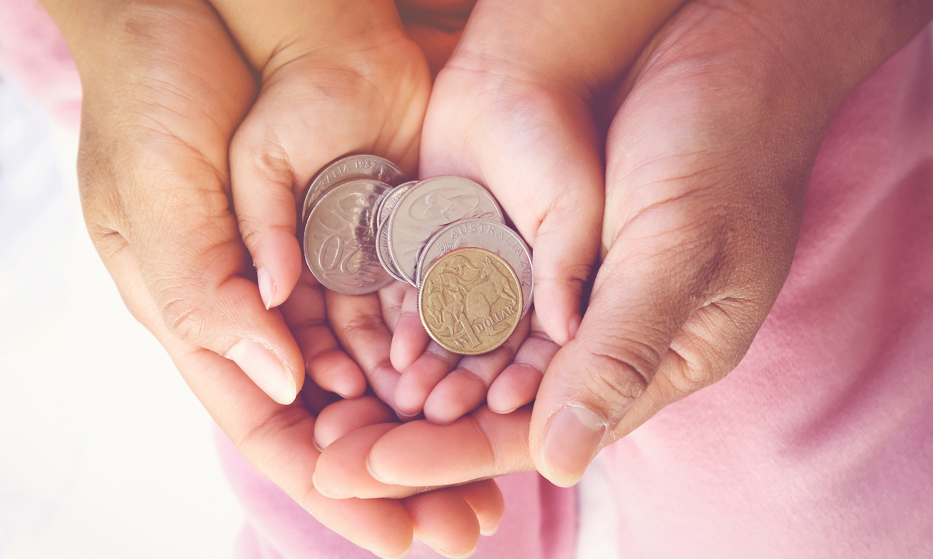 parent holding child hands with Australian money