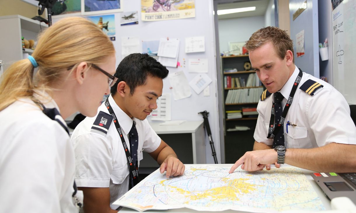three pilots plotting a course on a map