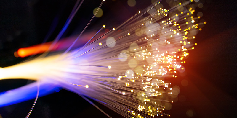 Photograph of some colourful fiber optics cables. The background is completely black.