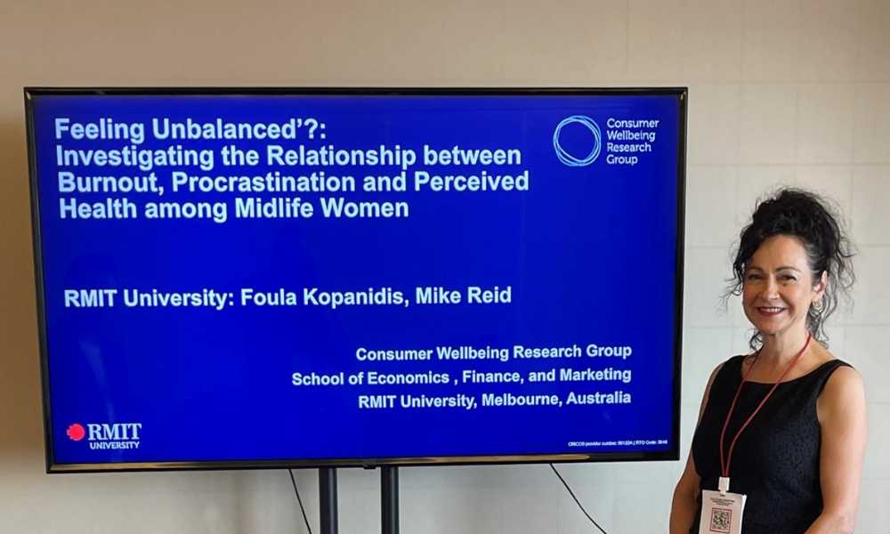 Person smiling next to screen with the words "Feeling unbalanced?: Investigating the relationship between burnout, procrastination and perceived health among midlife women