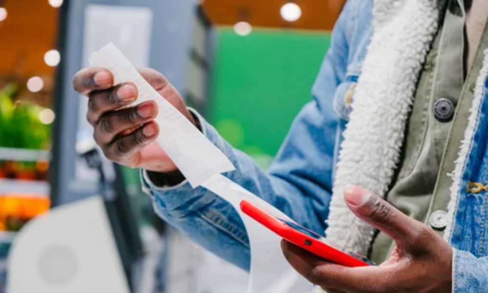 Person holding a mobile phone and receipt