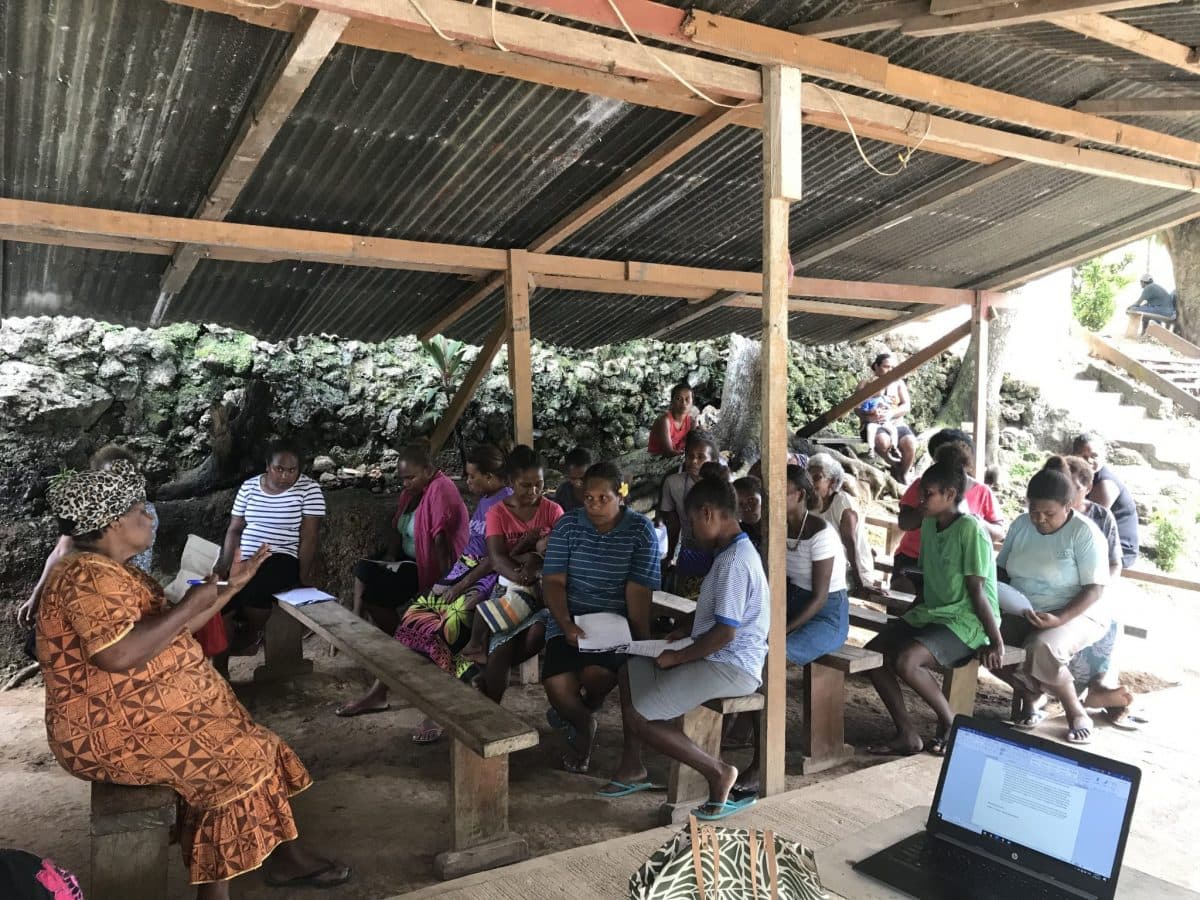 A group of men and children with sporting equipment.