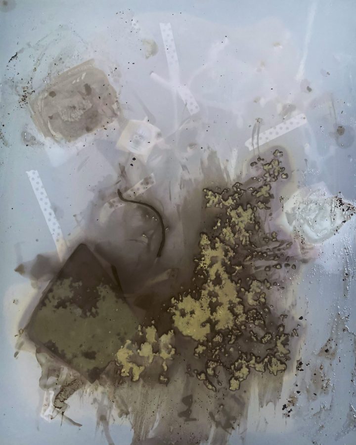 An abstract collage of material embedded in semi-opaque resin.
