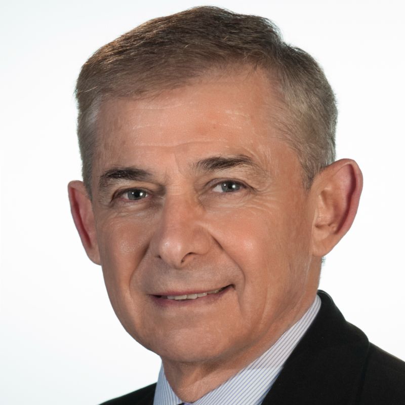 Alain Grossbard profile photo, he is wearing a suit and smiling