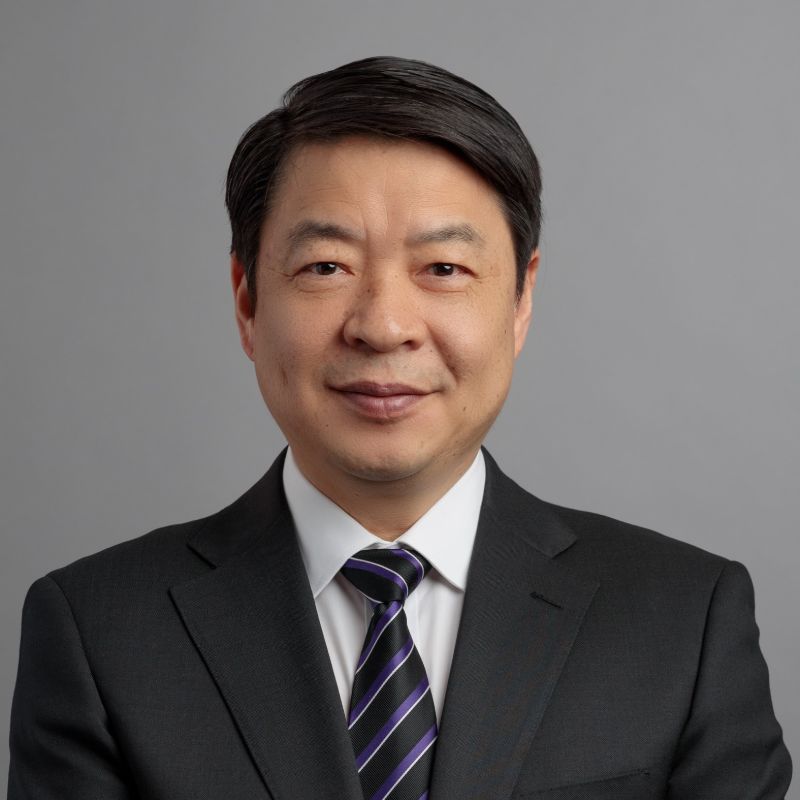 Profile photo of Yi Min Mike Xie in a suit. Mike is smiling towards the camera against a solid grey background.