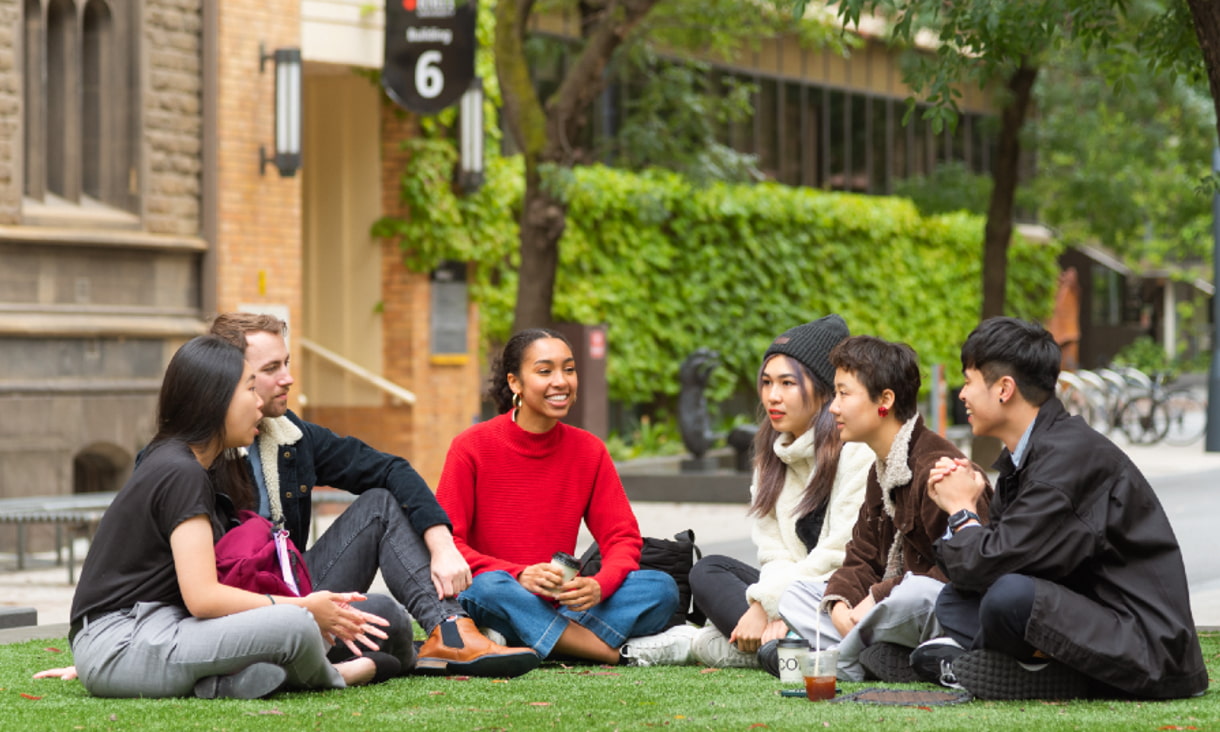 RMIT students on city campus sitting and chatting in front of Building 1