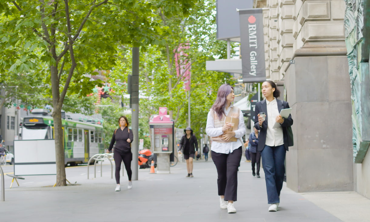 Two RMIT students walking together on the street in front of the RMIT Gallery