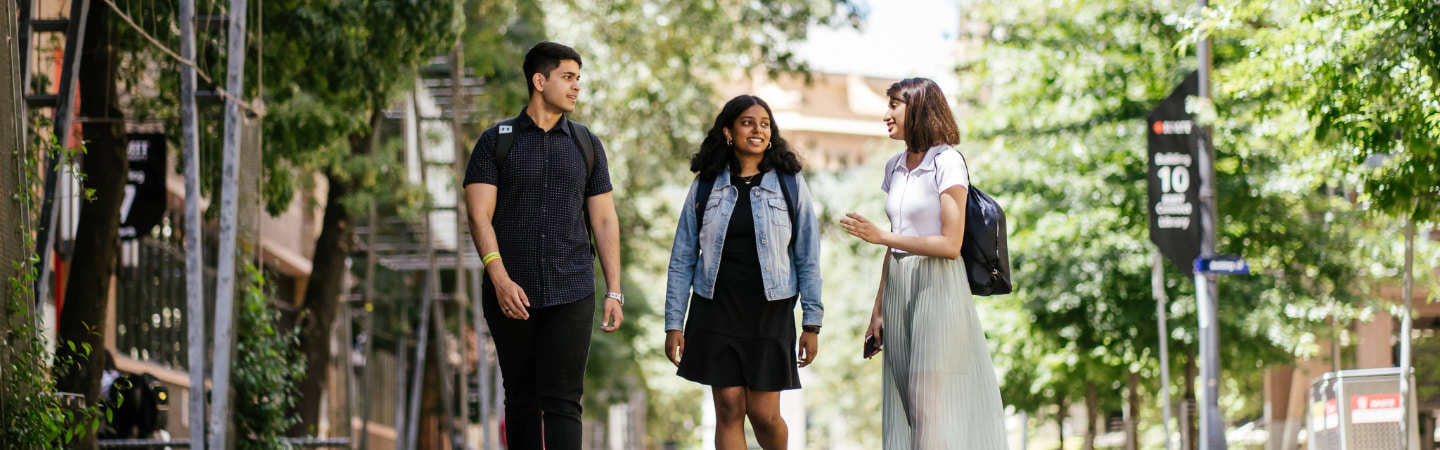 Three students walking along Bowen Street while talking