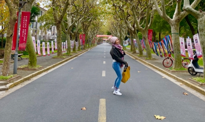 Female student on a tree-lined street