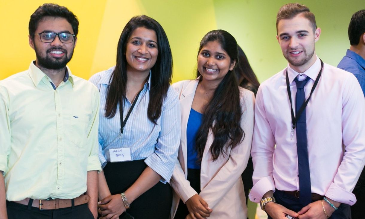 Group of students in business attire smiling at camera
