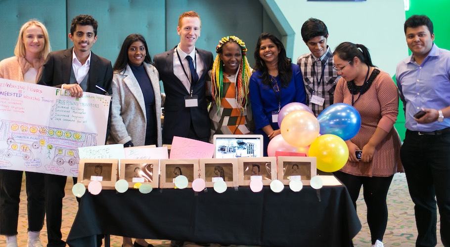 Group of students standing behind table with balloons