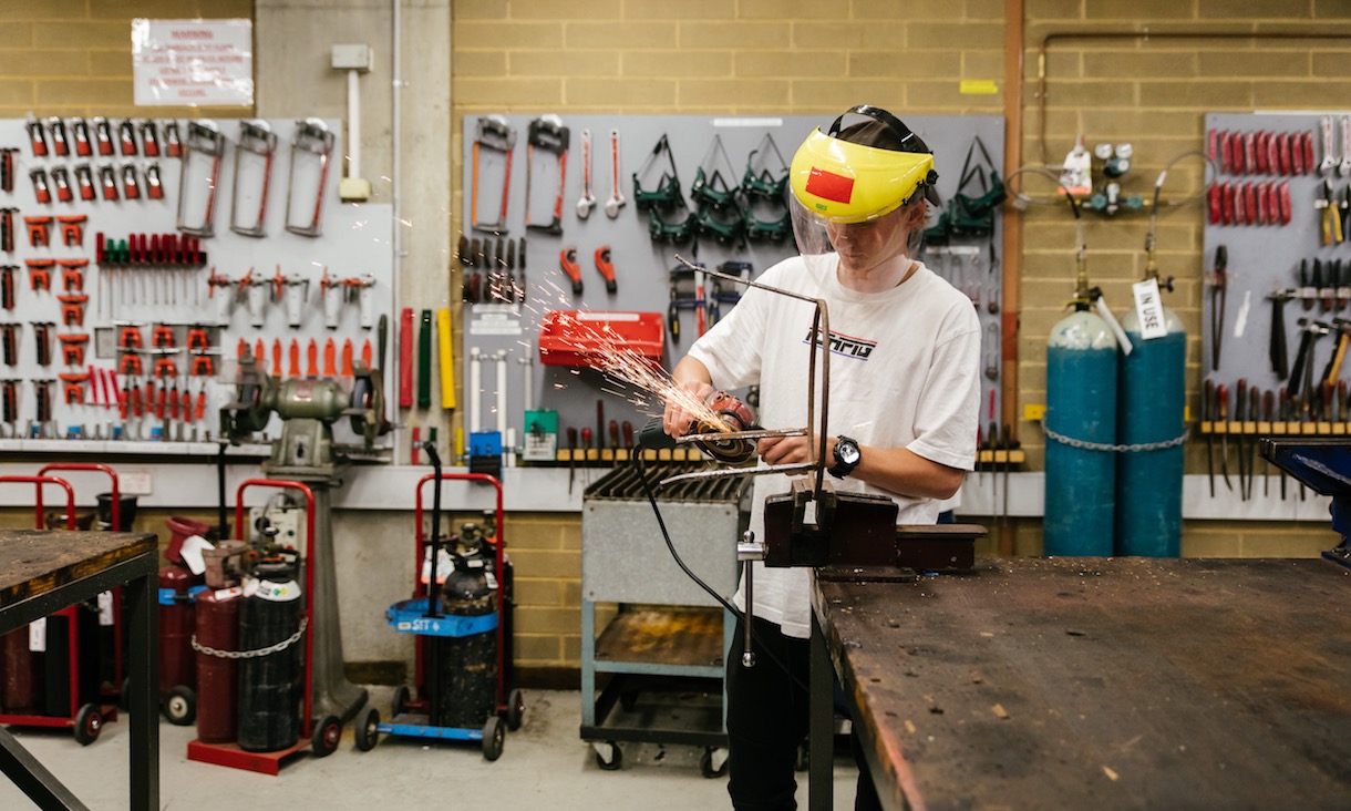 A student welds in a workshop.