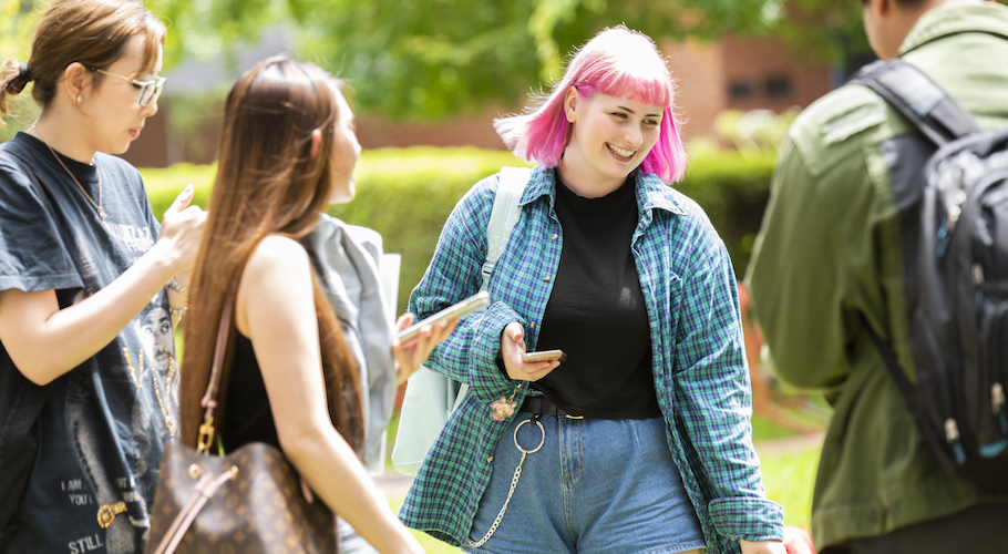 A group of students laugh together at Brunswick campus.