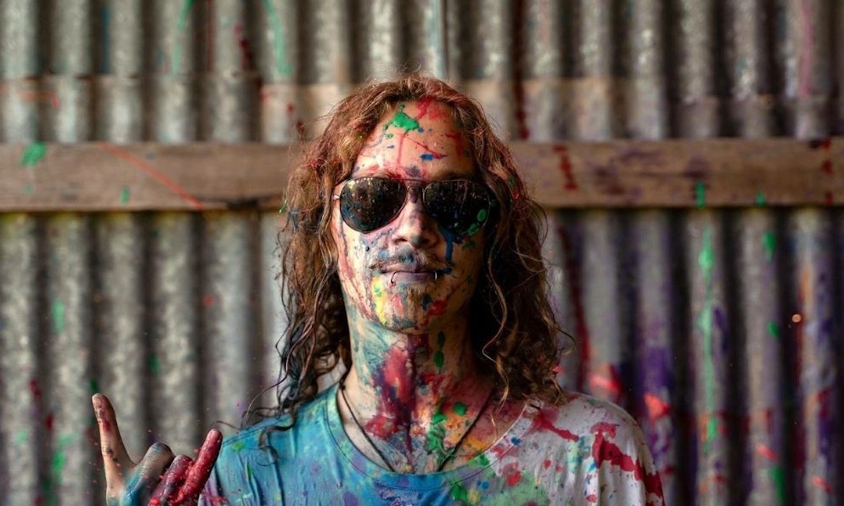 Image of a student covered in paint wearing sunglasses 