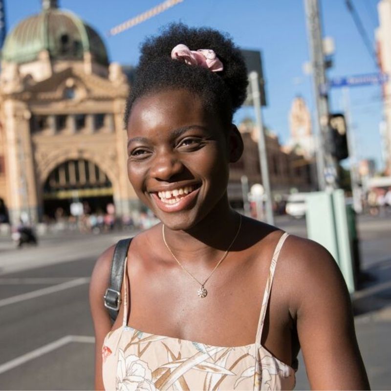 Profile photo. Smiling woman with Flinders Street Station in the background.