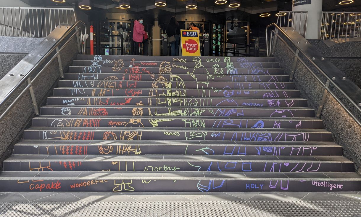 Stairs leading up to RMIT Building 8 with colourful drawings on each step/ 