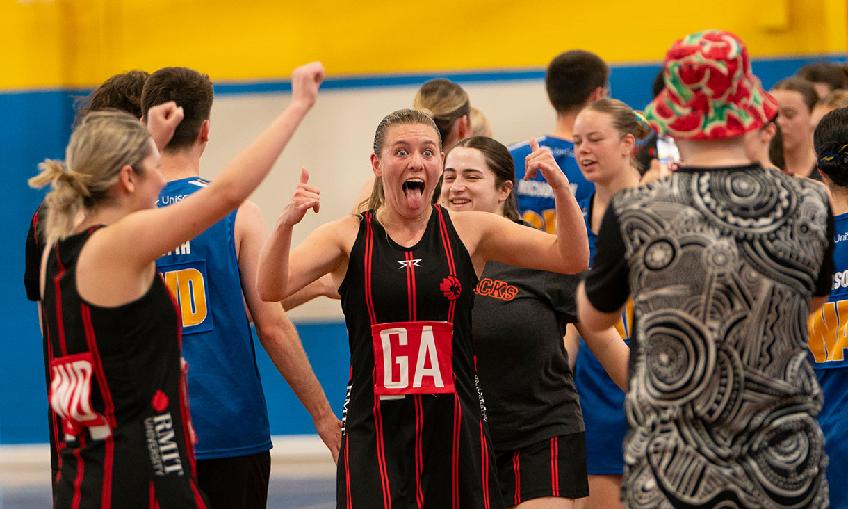 Woman celebrates with thumbs up after a netball game.