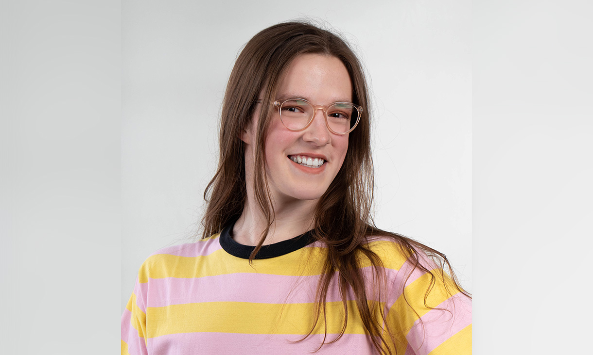 Portrait photo of woman with glasses smiling at camera.
