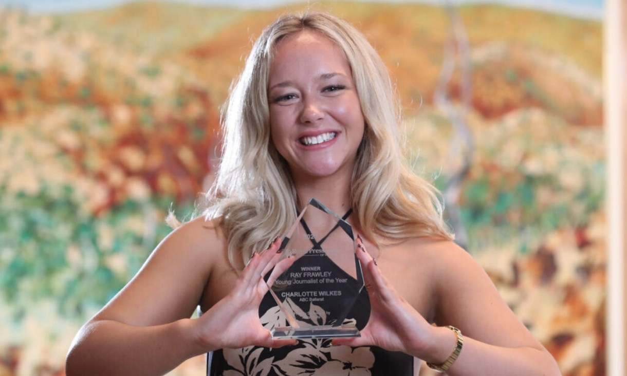 Person smiling holding trophy