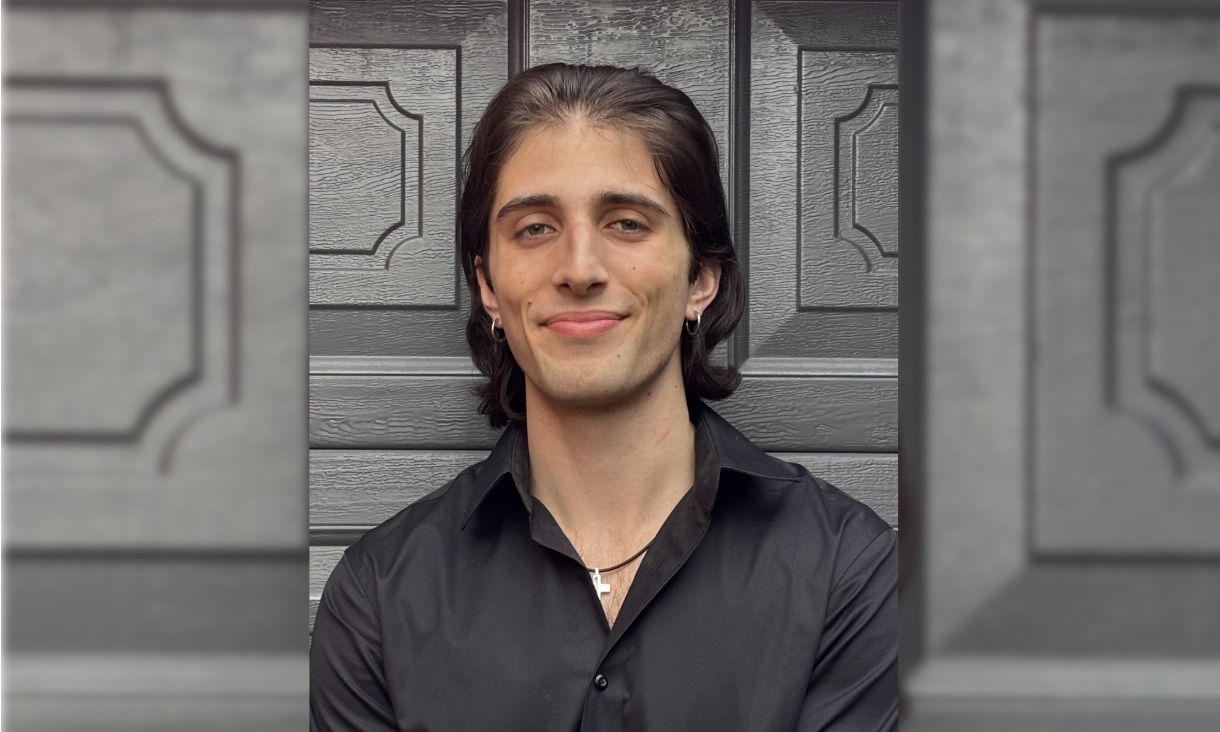 Roman wearing a black button up shirt pictured from chest up