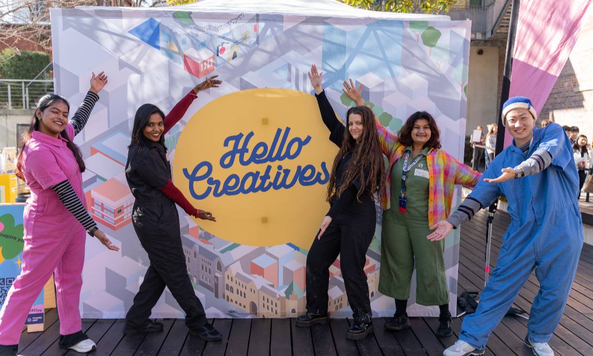 People in front of a banner that says hello creatives