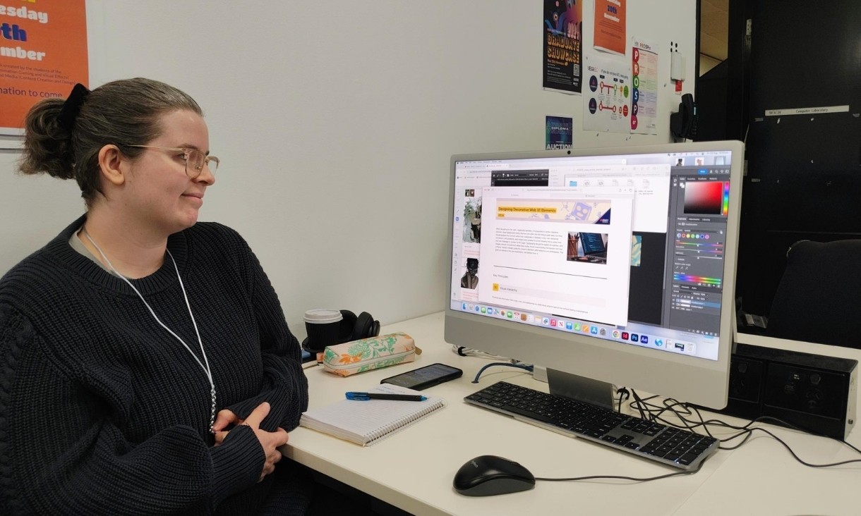 Lauren showing her banner design on computer screen