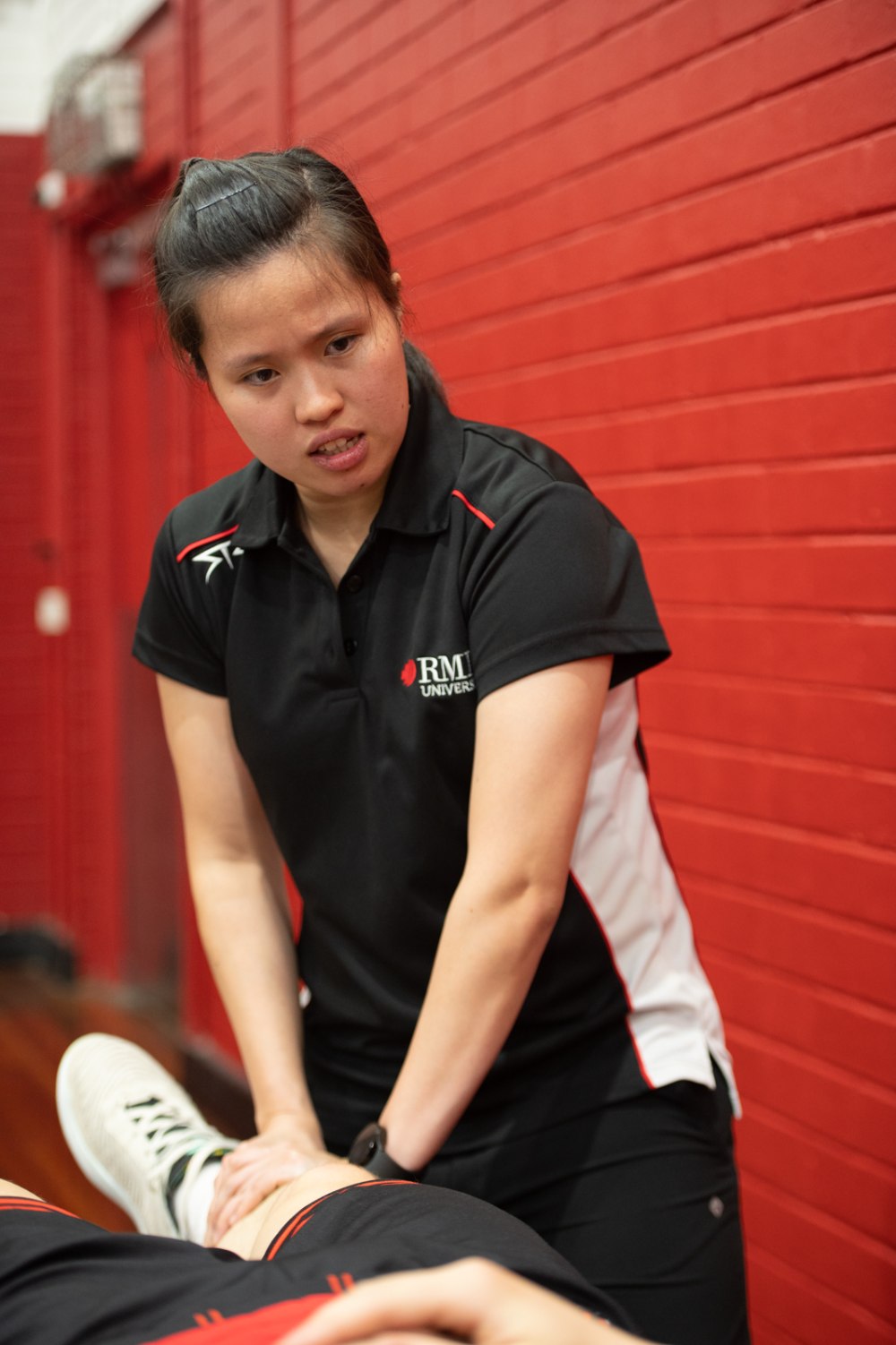 RMIT student administering a therapeutic massage during University Basketball League match