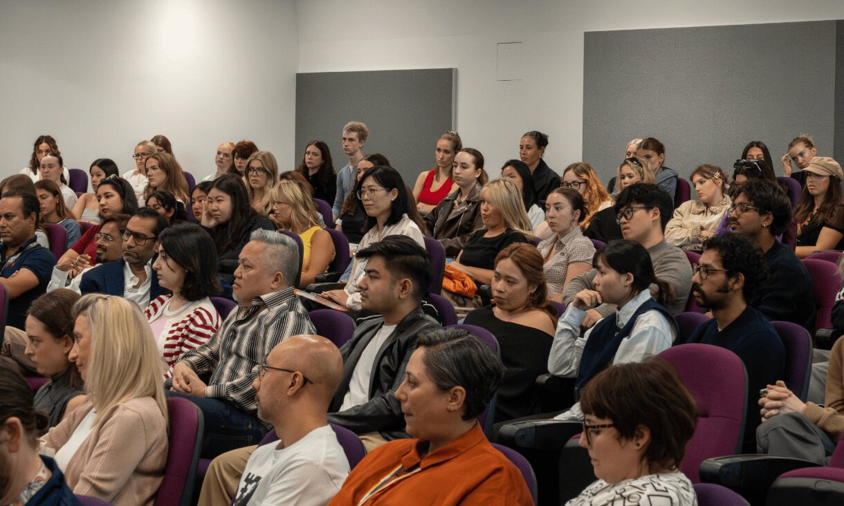 A group of students sit in a lecture theatre.