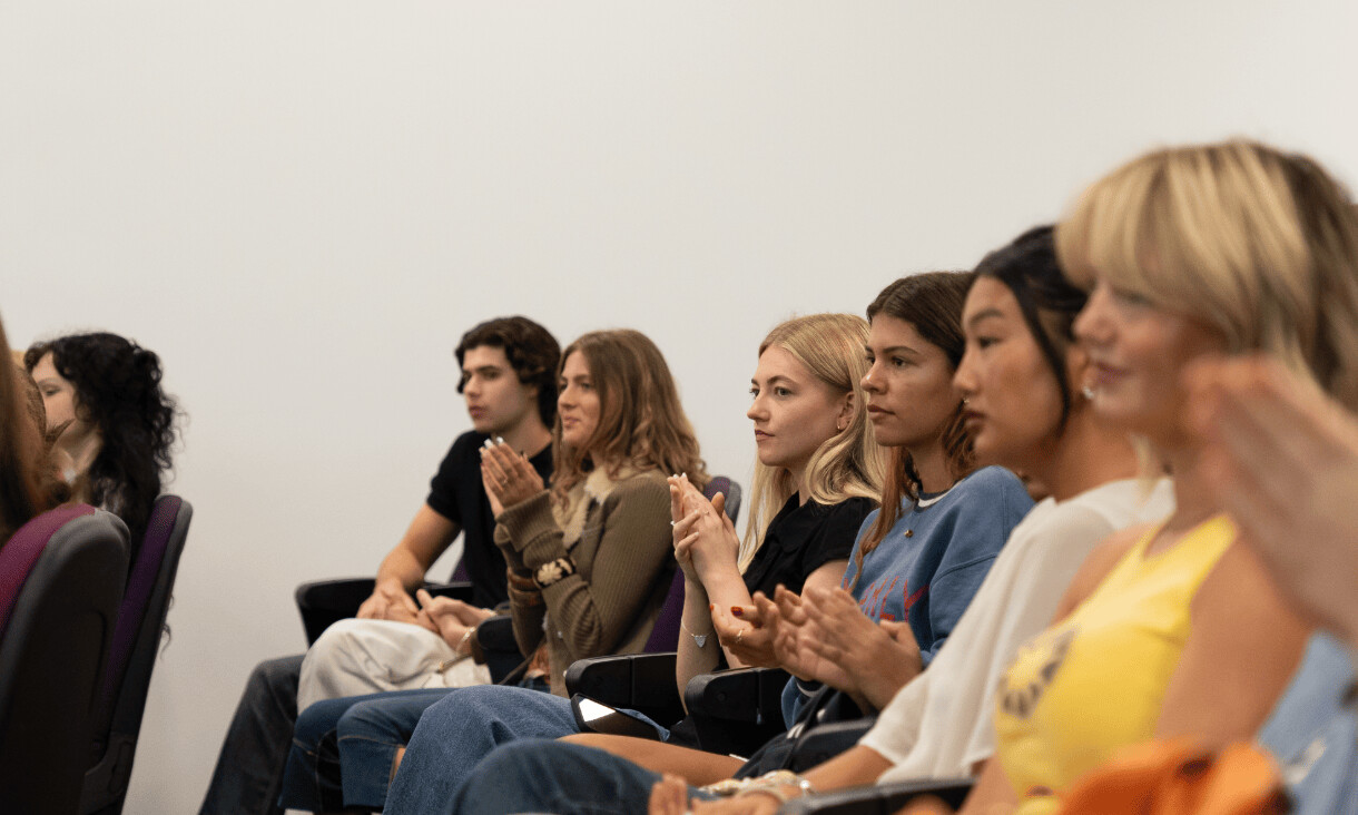 Close up of students listening to a presentation.