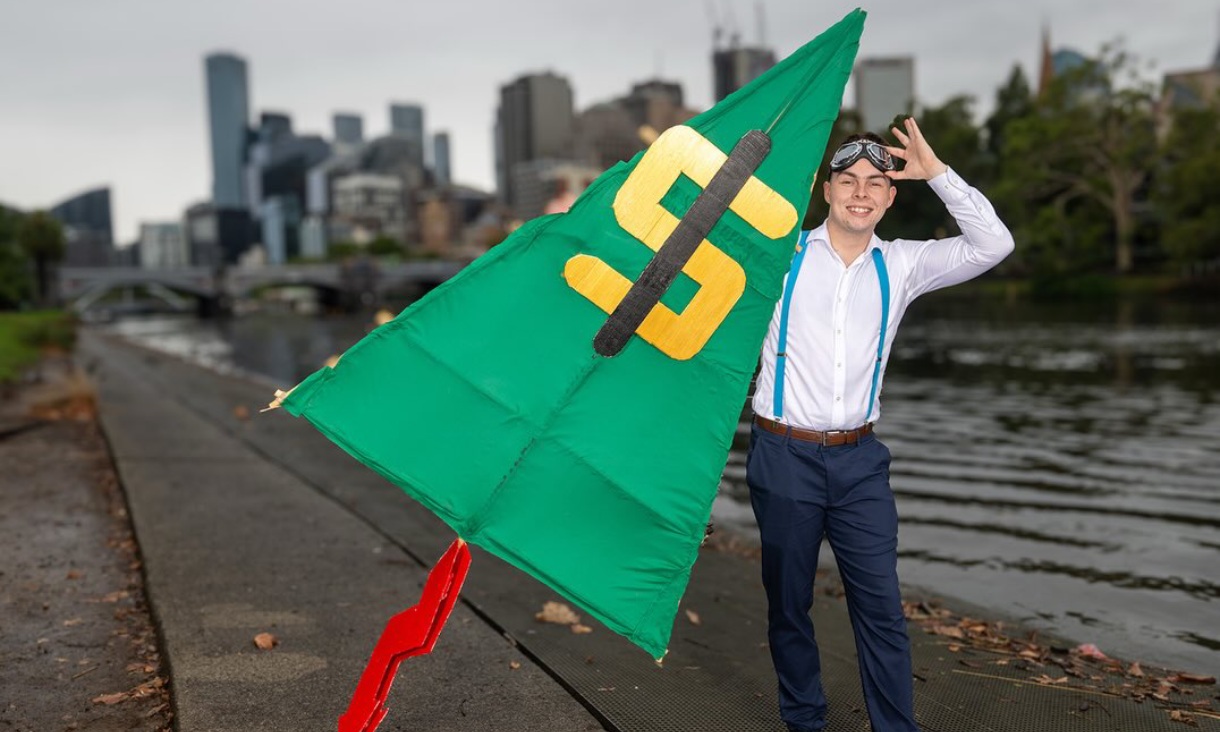 Person holding kite standing on site of river
