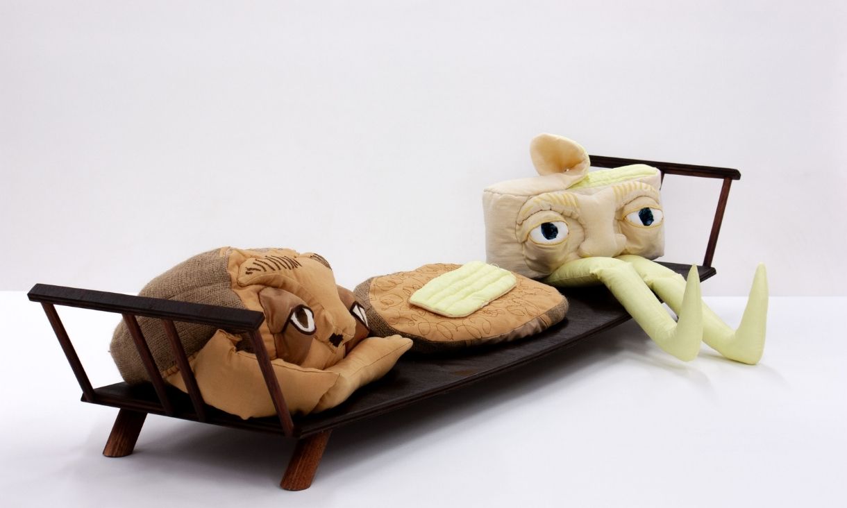 Sculpture of characters sitting on bed