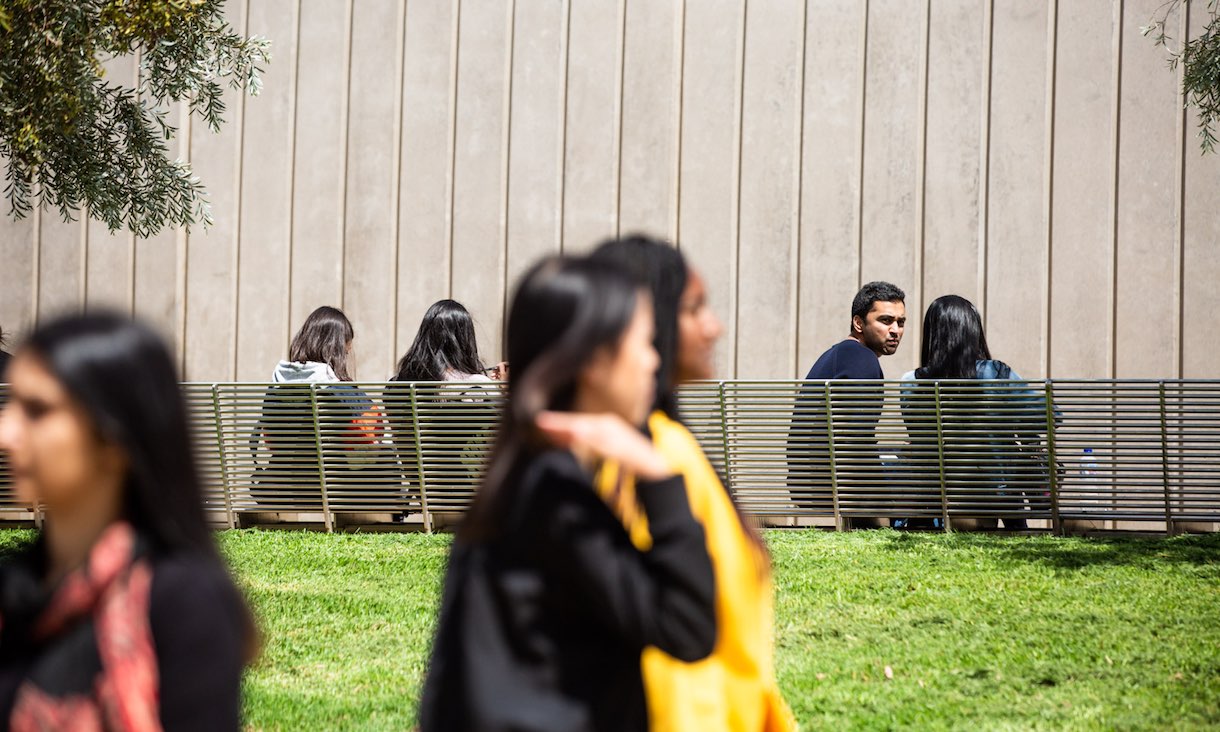 Students walking near Bundoora campus lawn.