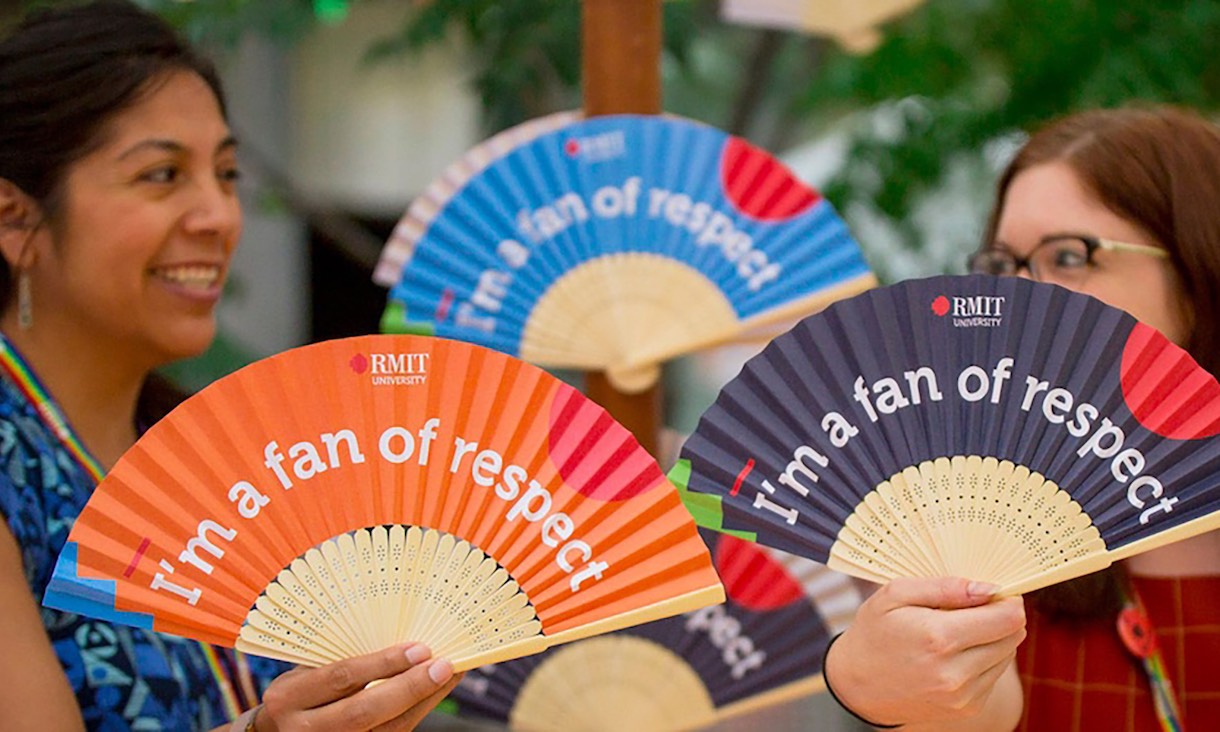 Students hold paper fans that read "I'm a fan of respect."