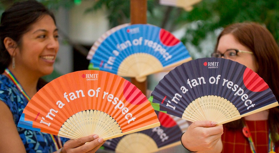 Students hold paper fans that read "I'm a fan of respect."