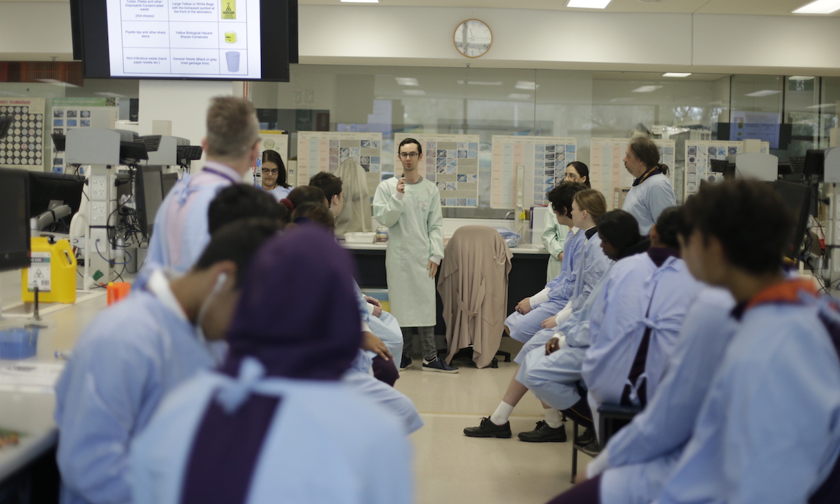 Young people wear lab coats in a laboratory classroom