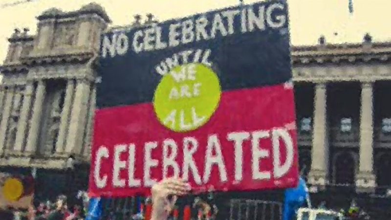 An Aboriginal flag that says "No celebrating until we are all celebrated".