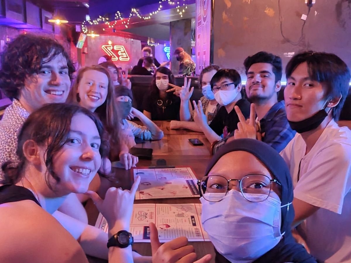 Friends pose for a selfie at a restaurant.