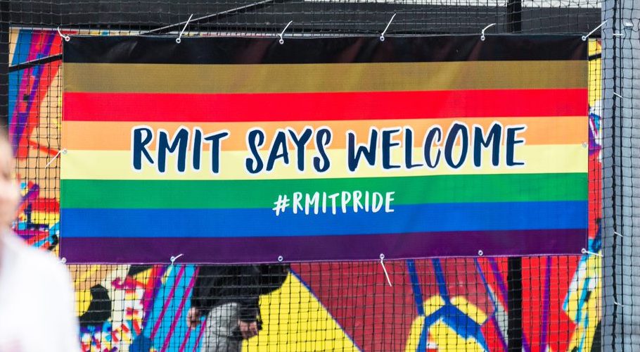 A photo of a rainbow flag that reads "RMIT says welcome".
