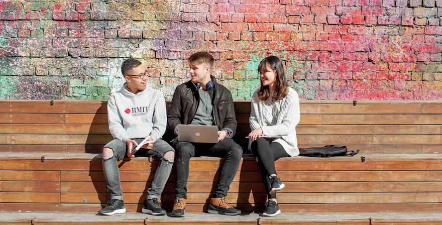 Two male and one female student sitting and talking at RMIT.
