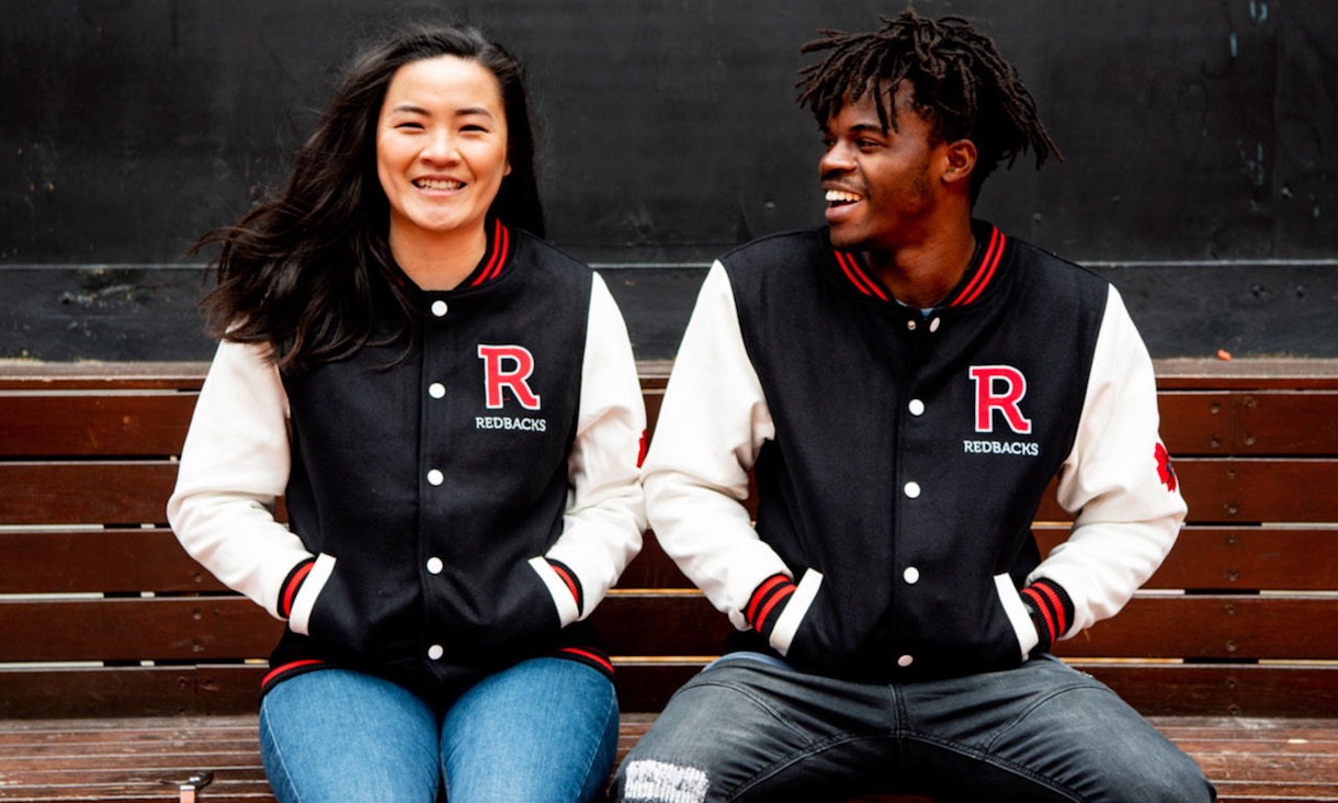 Two students wear RMIT-branded letterman jackets.