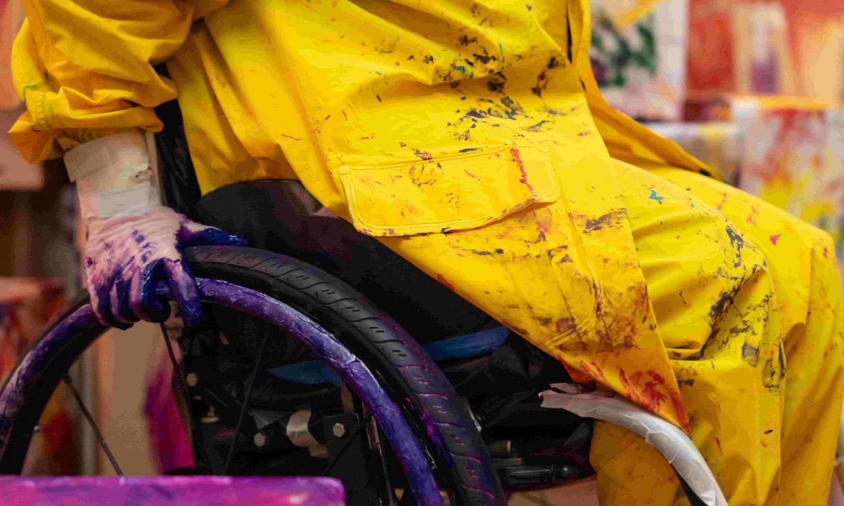 Colourful Mapiyal sculpture with greenery behind.