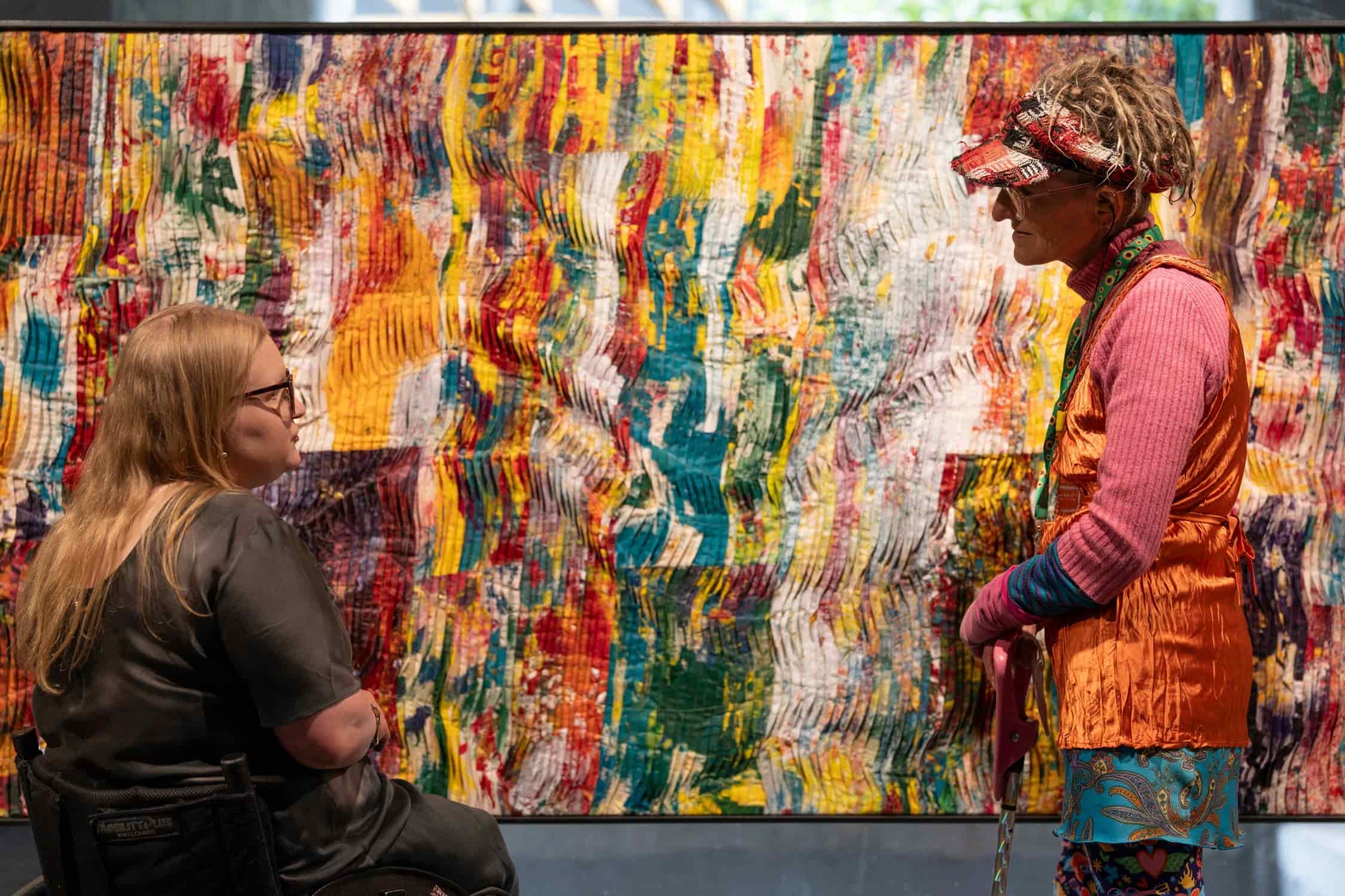 Colourful Mapiyal sculpture with greenery behind.