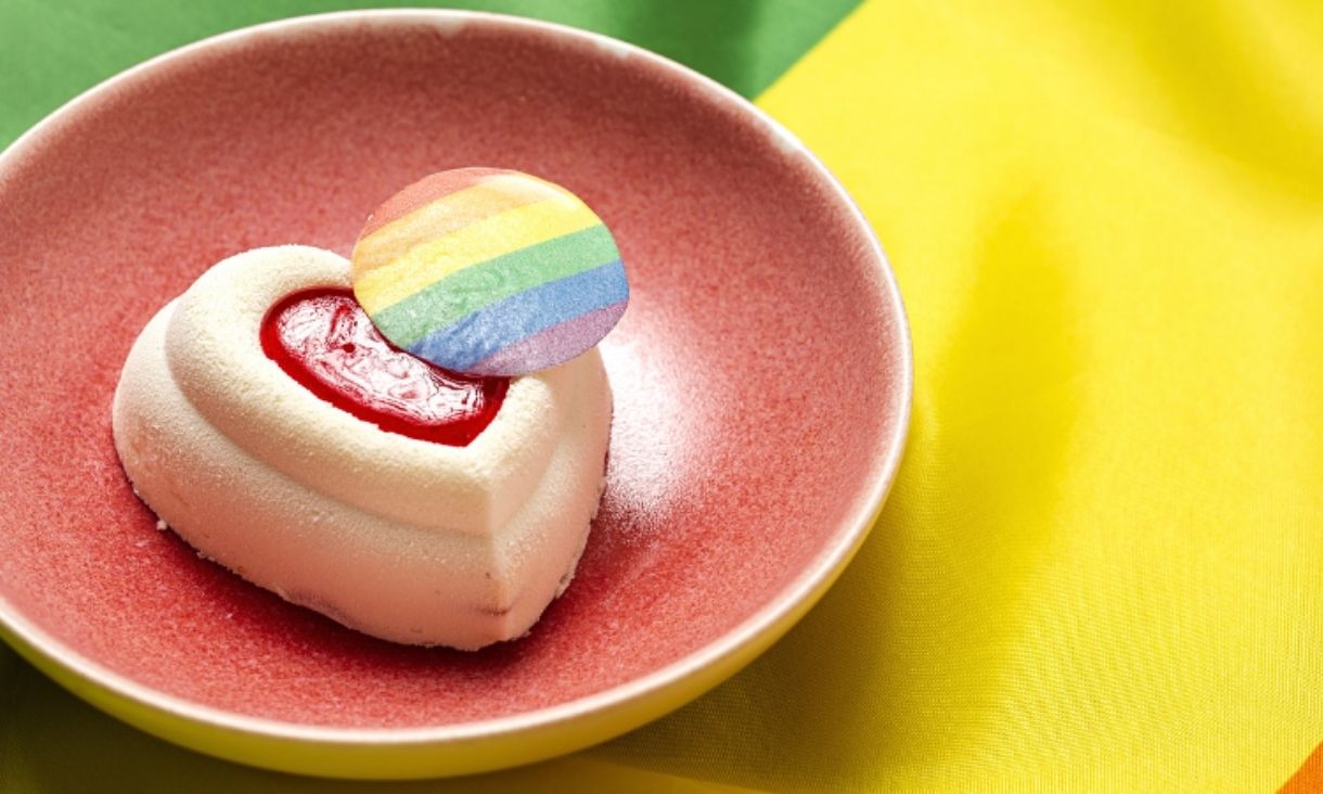 love heart cookie with pride sticker in bowl sitting on pride flag 