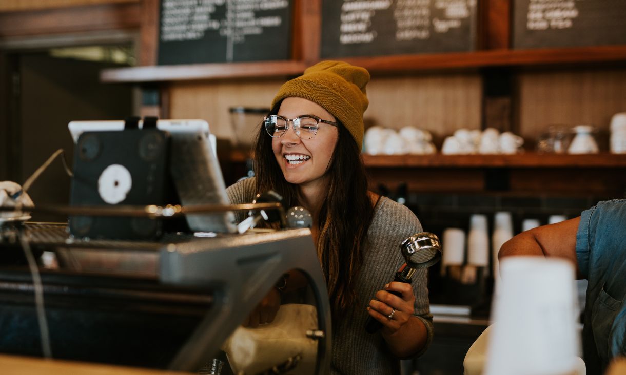 woman smiling at coffee machine 