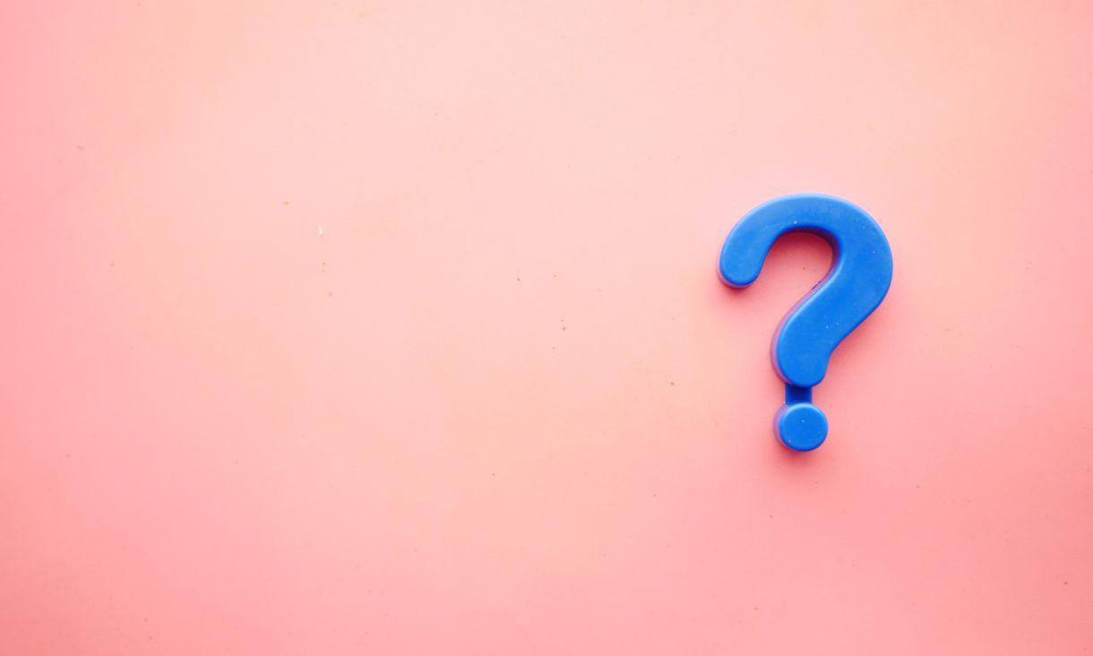 A question mark on a pink background.