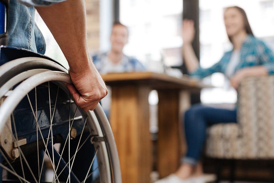 Stock image: Man in wheelchair meeting friends