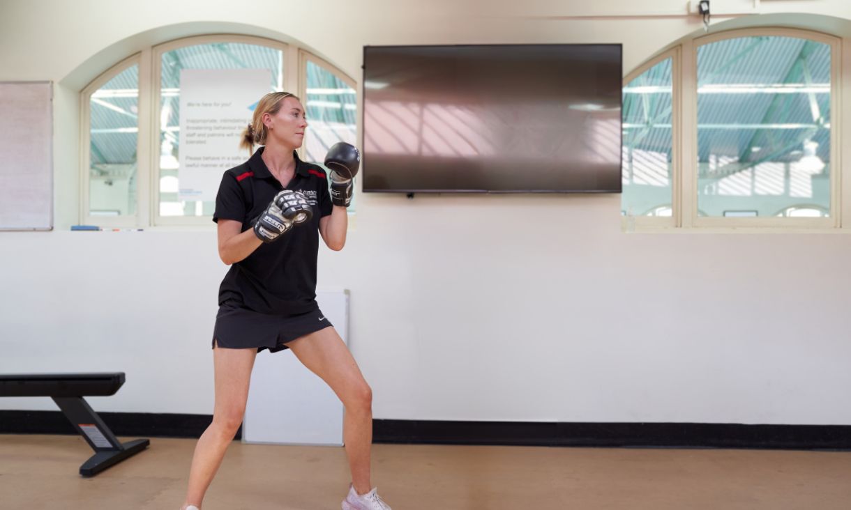 A person wearing boxing gloves in a fighting position